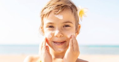 Sahildeki çocuk güneş kremi sürüyor. Seçici odaklanma. İnsanlar.