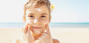 Sahildeki çocuk güneş kremi sürüyor. Seçici odaklanma. İnsanlar.