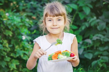 child eats vegetables. Summer photo. Selective focus nature