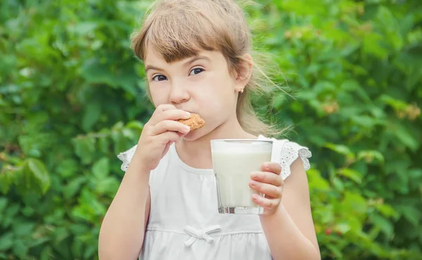 El niño bebe leche y galletas. Enfoque selectivo . — Foto de Stock
