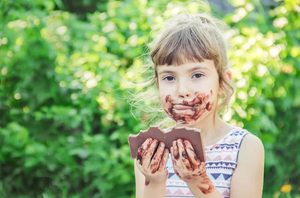 Un niño con dientes dulces come chocolate. Enfoque selectivo . — Foto de Stock