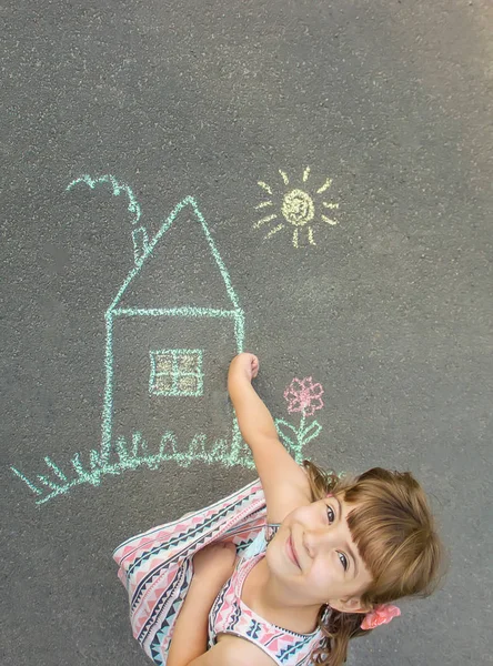 Niño dibuja una casa de tiza. Enfoque selectivo. —  Fotos de Stock