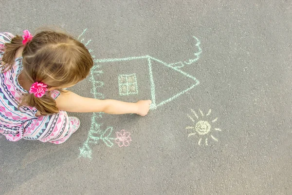 Kind zeichnet ein Kreidehaus. Selektiver Fokus. — Stockfoto