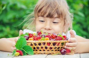 Çocuk bahçede kiraz topluyor. Seçici odak.