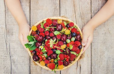 Çocuk bahçede kiraz topluyor. Seçici odak.