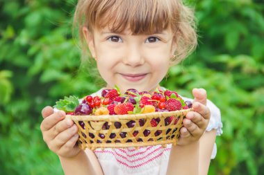 Çocuk bahçede kiraz topluyor. Seçici odak.