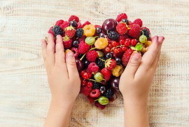 Çocuk bahçede kiraz topluyor. Seçici odak.