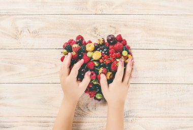 Çocuk bahçede kiraz topluyor. Seçici odak.