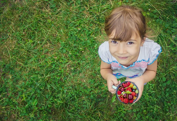 Anak itu memetik buah ceri di kebun. Fokus selektif. — Stok Foto