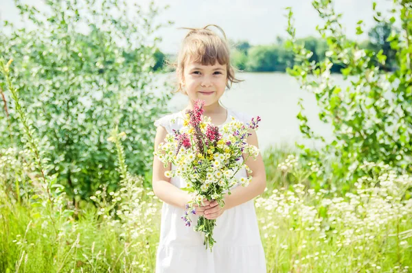 야생화의 꽃다발과 함께 아이입니다. 선택적 초점입니다. 자연. — 스톡 사진