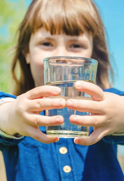 Gyermek pohár vizet. szelektív összpontosít. természet. — Stock Fotó