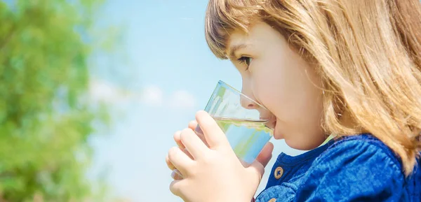 Bicchiere d'acqua bambino. concentrazione selettiva. natura . — Foto Stock