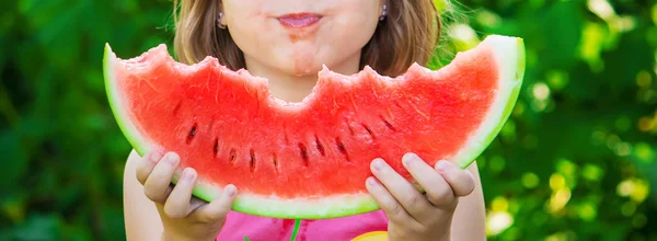 Ett barn äter vattenmelon. Selektivt fokus. Mat. — Stockfoto