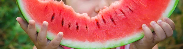 Ein Kind isst Wassermelone. Selektiver Fokus. Lebensmittel. — Stockfoto