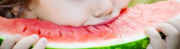 Uma criança come melancia. Foco seletivo. Alimentos . — Fotografia de Stock
