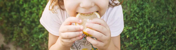 Kind mit einer Zitrone. Selektiver Fokus. Essen und Trinken. — Stockfoto