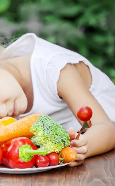 아이는 야채를 먹는다. 여름 사진입니다. 선택적 초점. — 스톡 사진