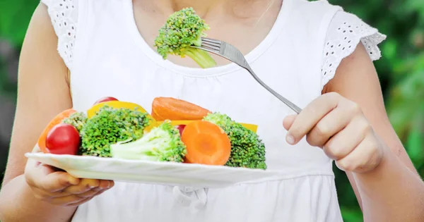아이는 야채를 먹는다. 여름 사진입니다. 선택적 초점. — 스톡 사진