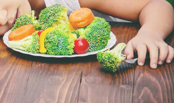 Criança come legumes. Foto de verão. Foco seletivo . — Fotografia de Stock