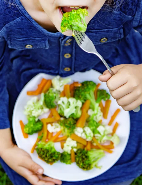 Παιδί τρώει λαχανικά. Καλοκαιρινή φωτογραφία. Επιλεκτική εστίαση — Φωτογραφία Αρχείου
