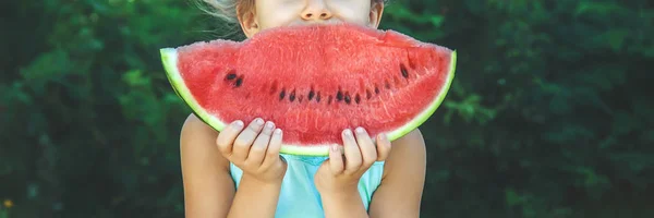 Ein Kind isst Wassermelone. Selektiver Fokus. Lebensmittel. — Stockfoto