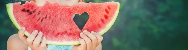 Ett barn äter vattenmelon. Selektivt fokus. Mat. — Stockfoto