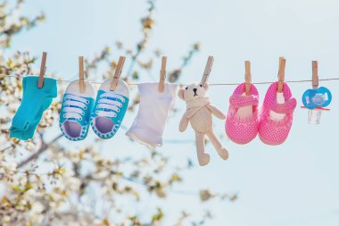 Bebek giysileri ve aksesuarları açık havada yıkandıktan sonra halat üzerinde tartMak. Seçici odaklama.