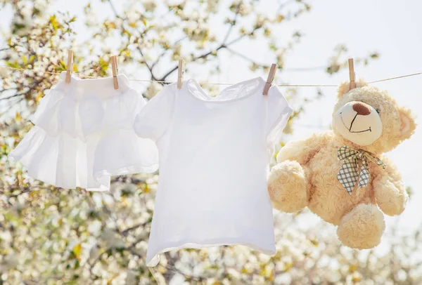 La ropa y los accesorios del bebé pesan sobre la cuerda después de lavarse al aire libre. Enfoque selectivo . —  Fotos de Stock