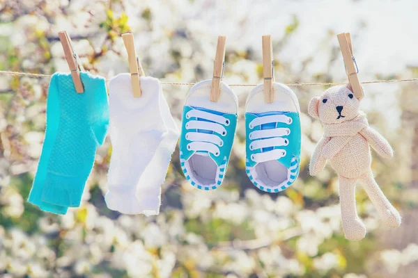 La ropa y los accesorios del bebé pesan sobre la cuerda después de lavarse al aire libre. Enfoque selectivo . —  Fotos de Stock