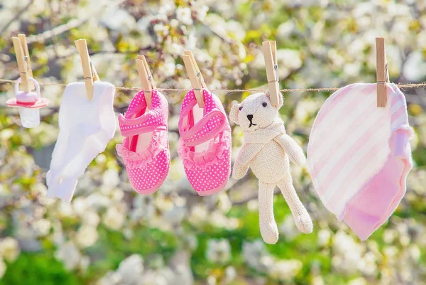 Baby kleding en accessoires wegen op het touw na het wassen in de open lucht. Selectieve focus. — Stockfoto