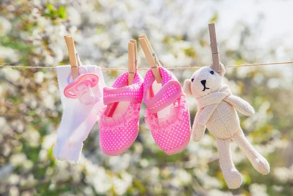 Baby kleding en accessoires wegen op het touw na het wassen in de open lucht. Selectieve focus. — Stockfoto