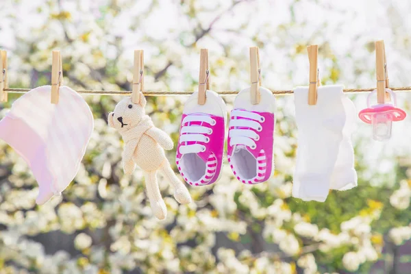 Baby kleding en accessoires wegen op het touw na het wassen in de open lucht. Selectieve focus. — Stockfoto