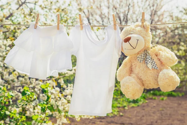 La ropa y los accesorios del bebé pesan sobre la cuerda después de lavarse al aire libre. Enfoque selectivo . —  Fotos de Stock