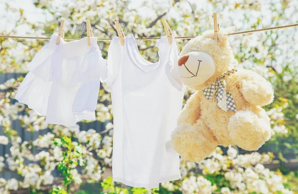 Babybekleidung und Accessoires wiegen nach dem Waschen im Freien auf dem Seil. Selektiver Fokus. — Stockfoto