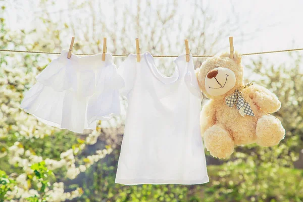 La ropa y los accesorios del bebé pesan sobre la cuerda después de lavarse al aire libre. Enfoque selectivo . —  Fotos de Stock