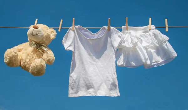 Ubrania dla niemowląt i akcesoria ważą na linę po umyciu na otwartym powietrzu. Selektywna koncentracja. — Zdjęcie stockowe