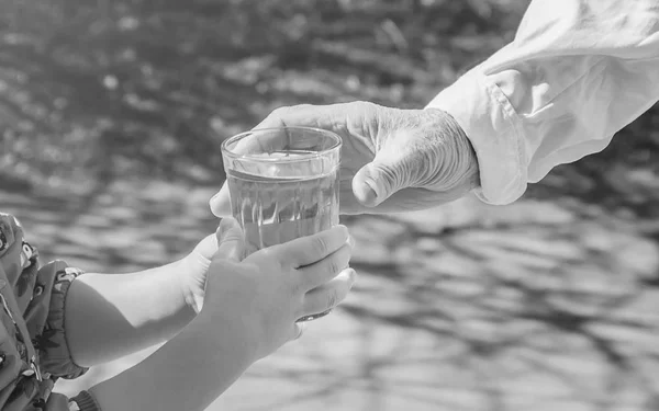 Grandmother giving a glass of clean water to a child. Selective focus. — Stock Photo, Image