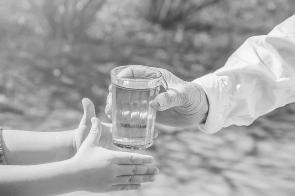 Бабуся дає дитині склянку чистої води. Вибірковий фокус . — стокове фото