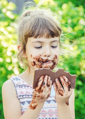 Tatlı dilli çocuk çikolata yiyor. Seçici odak.