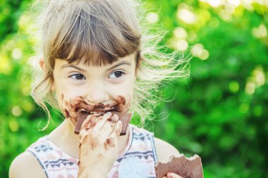 Tatlı dilli çocuk çikolata yiyor. Seçici odak.