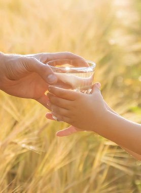 Baba çocuk bir bardak su verir. Seçici odak.