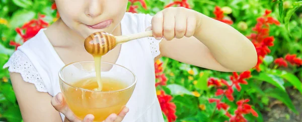 Barnet äter honung. Selektivt fokus. natur — Stockfoto