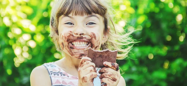 Ένα γλυκό-οδοντωτό παιδί τρώει σοκολάτα. Επιλεκτική εστίαση. — Φωτογραφία Αρχείου