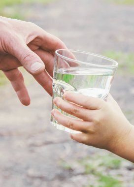 Baba çocuk bir bardak su verir. Seçici odak.