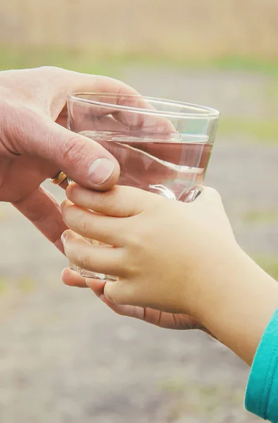Батько дає дитині склянку води. Вибірковий фокус . — стокове фото