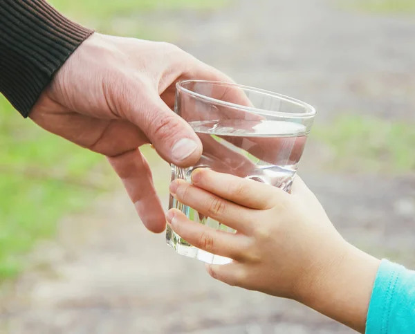 O pai dá à criança um copo de água. Foco seletivo . — Fotografia de Stock