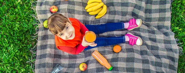 Ребенок на пикнике с соком и фруктами. Селективный фокус . — стоковое фото