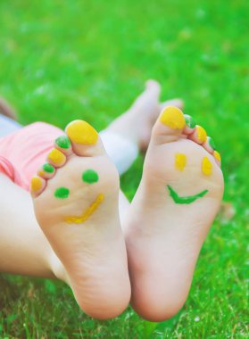 Çocuk yeşil çimlerin üzerinde yatıyor. Çocuk bahar parkında eğleniyor..