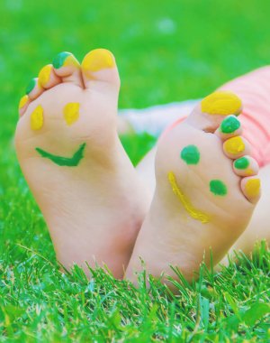 Çocuk yeşil çimlerin üzerinde yatıyor. Çocuk bahar parkında eğleniyor..