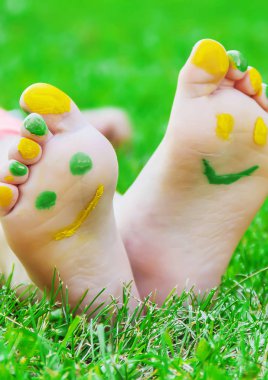 Çocuk yeşil çimlerin üzerinde yatıyor. Çocuk bahar parkında eğleniyor..